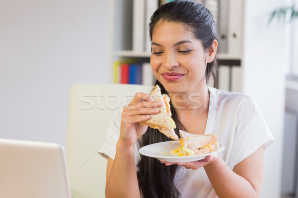 Mujer de negocios comer sándwich pausa para el almuerzo jóvenes sonriendo Foto stock © wavebreak_media