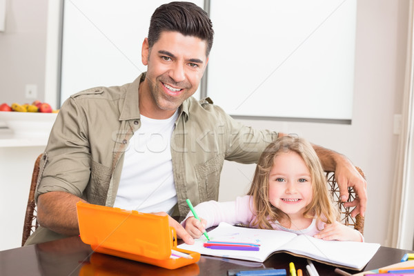 Happy little girl colouring at the table with her father Stock photo © wavebreak_media