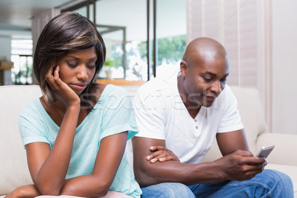 Stock photo: Unhappy woman watching her boyfriend texting