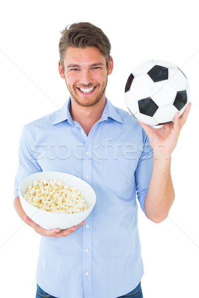 Handsome young man holding ball and popcorn Stock photo © wavebreak_media