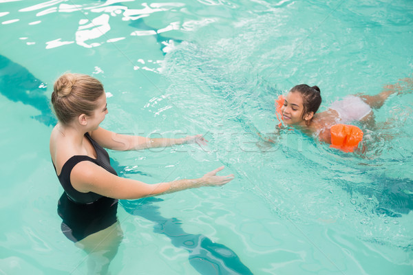 Cute little girl learning to swim with coach Stock photo © wavebreak_media