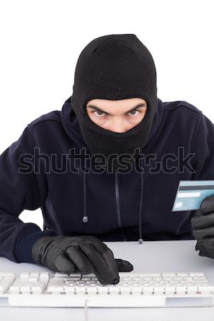 Burglar with sunglasses typing on keyboard Stock photo © wavebreak_media