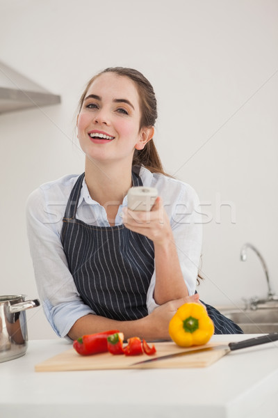 Pretty brunette cooking and watching tv Stock photo © wavebreak_media