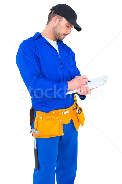 Handyman in blue overall writing on clipboard Stock photo © wavebreak_media