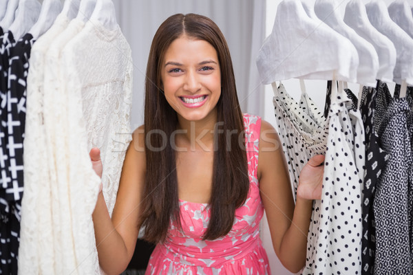 Portrait of smiling woman standing in-between clothes Stock photo © wavebreak_media