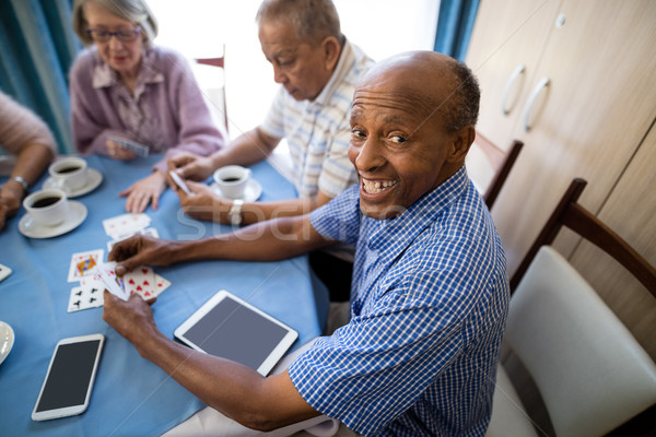 Felice senior uomo carte da gioco amici tavolino da caffè Foto d'archivio © wavebreak_media