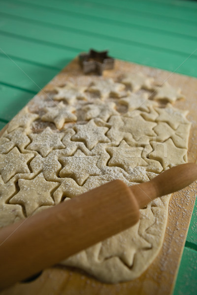 Stock photo: Close up star shape cookies on dough with rolling pin