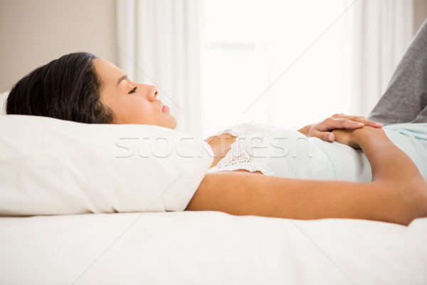 Bruneta mâini stomac pat acasă femeie Imagine de stoc © wavebreak_media