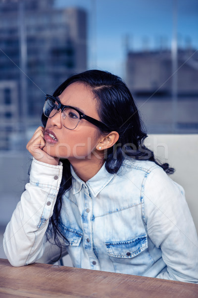 Troubled Asian woman with chin on fist Stock photo © wavebreak_media