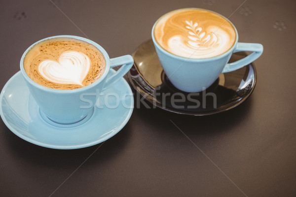 Cup of cappuccino with coffee art on wooden table Stock photo © wavebreak_media