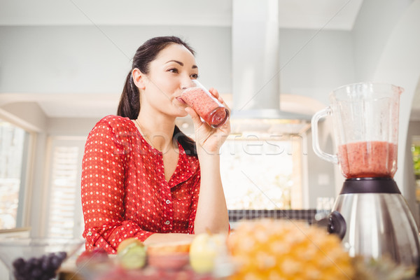 Mujer sonriente potable jugo de fruta pie casa mujer Foto stock © wavebreak_media