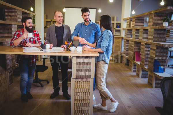 [[stock_photo]]: Collègues · serrer · la · main · table · bureau · Creative · femme