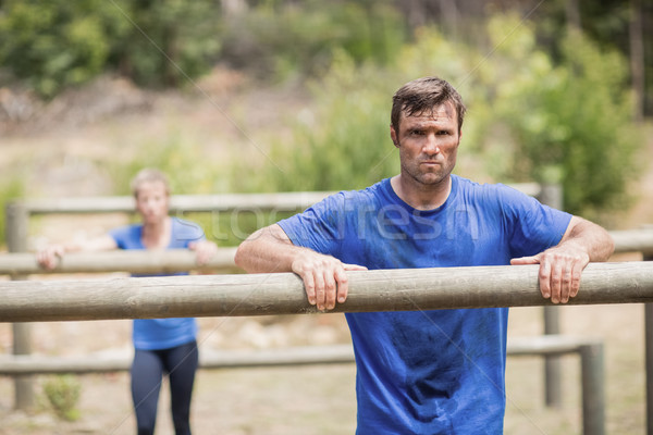 Tired man and woman leaning on a hurdle during obstacle course Stock photo © wavebreak_media