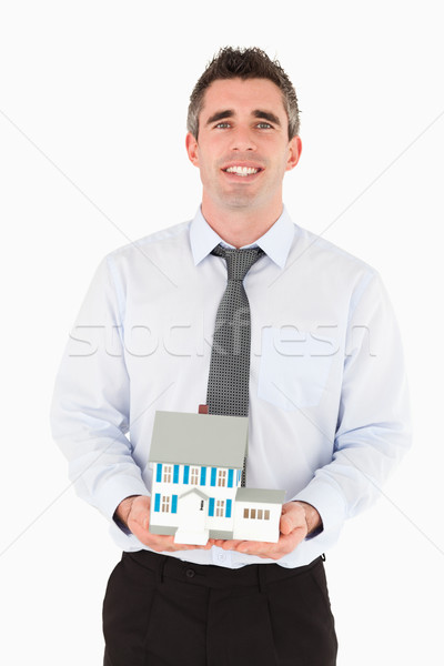 Businessman holding a miniature house against a white background Stock photo © wavebreak_media