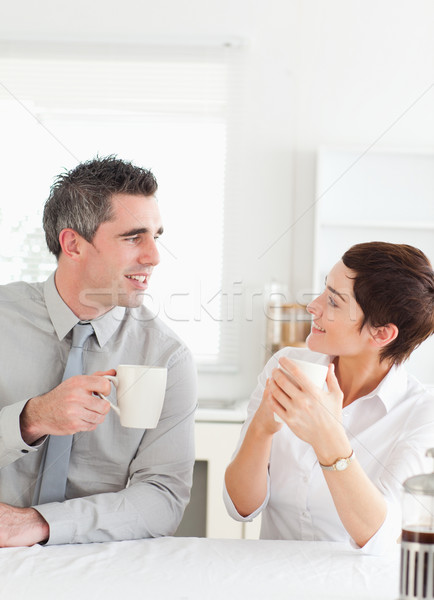 Stock photo: Smiling couple drinking coffee in a kitchen