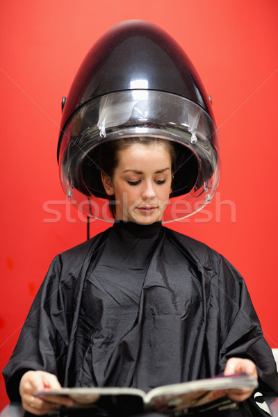 Portrait of a woman under a hairdressing machine against a red background Stock photo © wavebreak_media