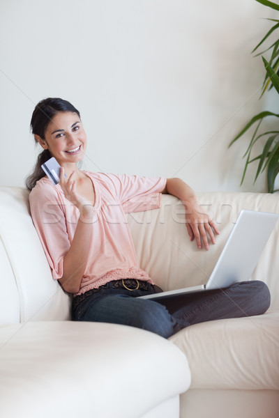 Retrato encantado mulher compras on-line sala de estar Foto stock © wavebreak_media