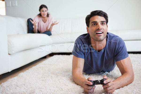 Man playing video games while his fiance is getting mad at him in their living room Stock photo © wavebreak_media