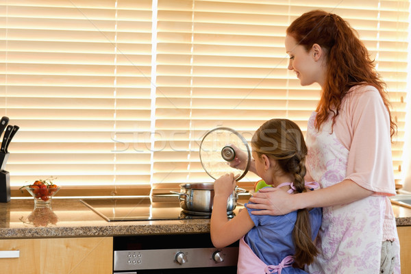 Stock photo: Mother and daughter cooking a meal together