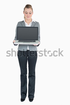 Businesswoman smiling while showing a laptop screen against white background Stock photo © wavebreak_media