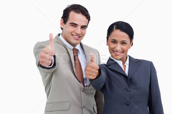 Smiling salespeople giving thumbs up against a white background Stock photo © wavebreak_media
