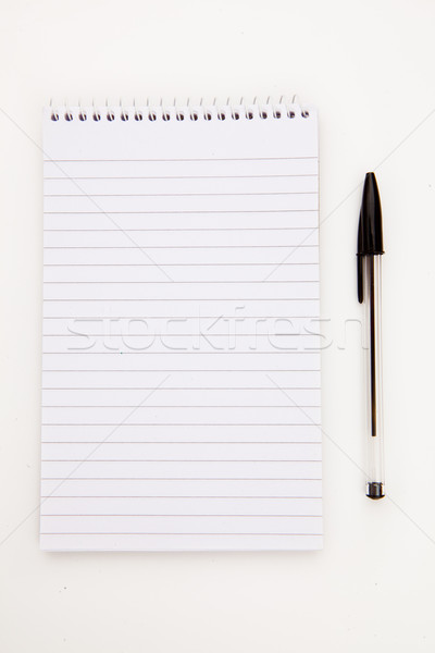 Stock photo: Notepad  with black pen sheet  against a white background