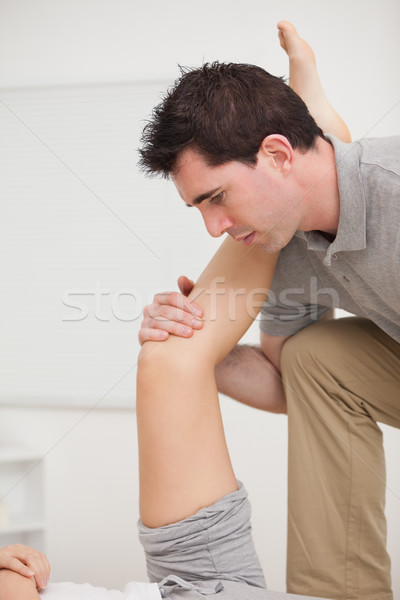 Serious osteopath holding a leg in a room Stock photo © wavebreak_media