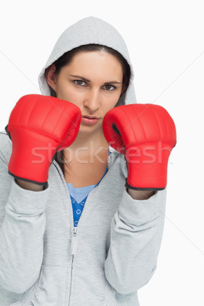 Brunette in sweatshirt wearing boxing gloves against white background Stock photo © wavebreak_media