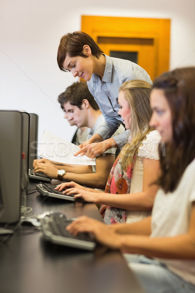 Stock photo: Teacher explaining to the student at the computer room of college