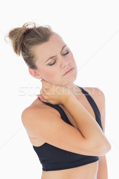 Woman holding hand to stiff neck with eyes closed in sportswear Stock photo © wavebreak_media