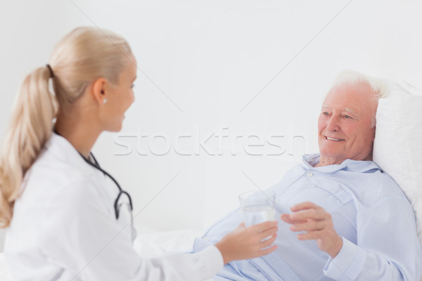 Doctor handing glass of water to patient Stock photo © wavebreak_media