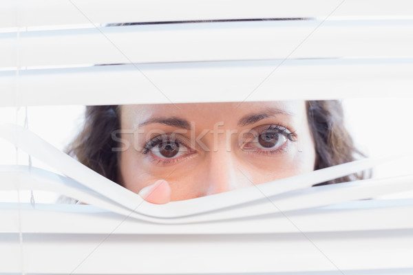 Curious woman looking through blinds Stock photo © wavebreak_media