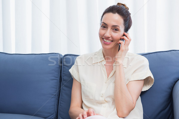 Casual brunette making phone call on couch Stock photo © wavebreak_media