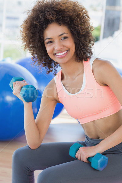 Smiling young woman exercising with dumbbells in gym Stock photo © wavebreak_media