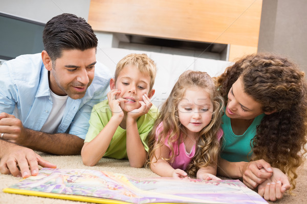 Cute siblings lying on the rug reading storybook with their pare Stock photo © wavebreak_media