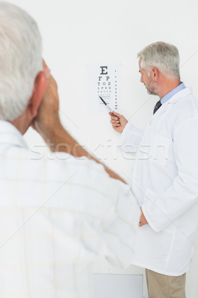 Pediatrician ophthalmologist with senior patient pointing at eye Stock photo © wavebreak_media