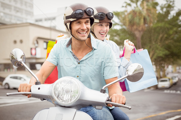 Hip young couple riding scooter with shopping bags Stock photo © wavebreak_media