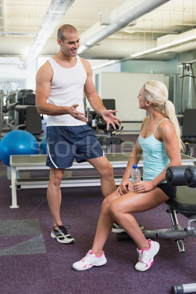 Stock photo: Male trainer talking to fit woman at gym