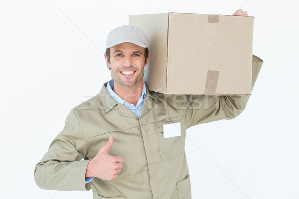 Delivery man showing thumbs up while carrying cardboard box Stock photo © wavebreak_media