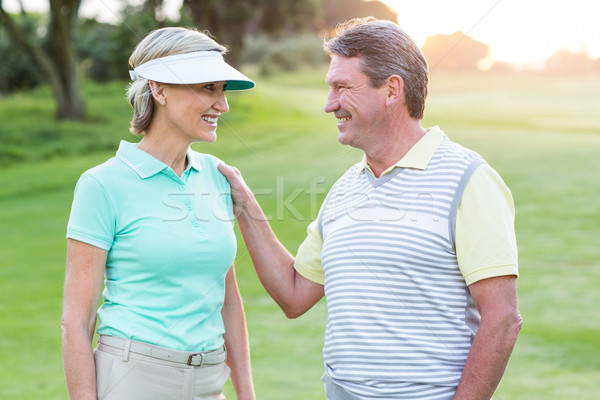Golfing couple smiling at camera on the putting green  Stock photo © wavebreak_media