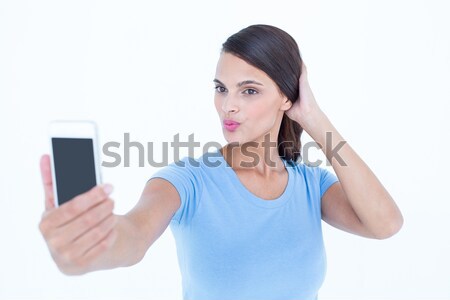 Pretty brunette taking a selfie with smartphone Stock photo © wavebreak_media