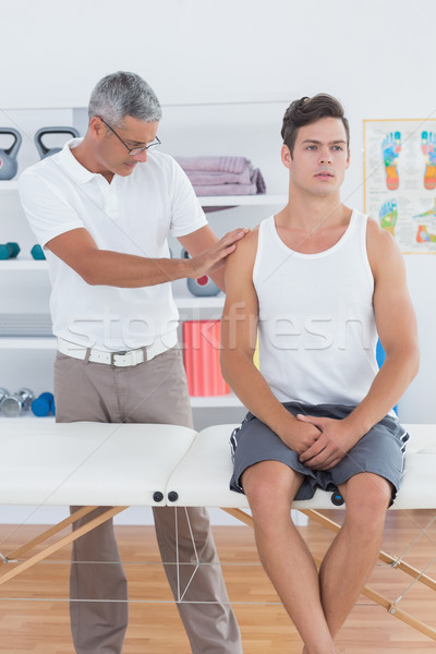 Doctor examining his patient shoulder  Stock photo © wavebreak_media