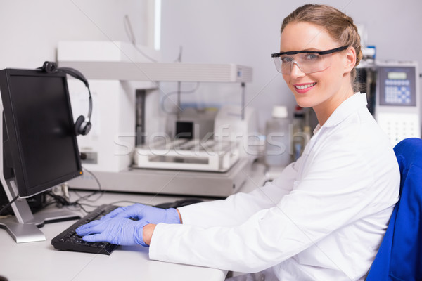 Smiling scientist looking at camera and using computer Stock photo © wavebreak_media