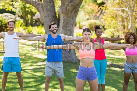 Stock photo: Trainer assisting senior people in exercising
