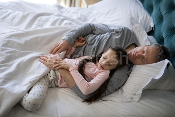 Father and daughter sleeping together on bed in bedroom Stock photo © wavebreak_media