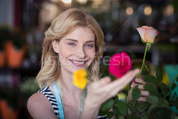 Smiling female florist arranging flower bouquet in vase at flower shop Stock photo © wavebreak_media