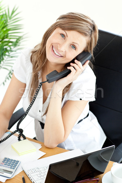 Gladsome woman sitting on a chair in her office and phoneing Stock photo © wavebreak_media