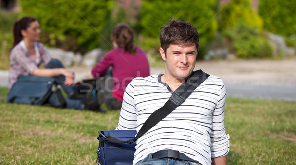 Positive male student lying on the grass with his schoolbag at his university campus Stock photo © wavebreak_media