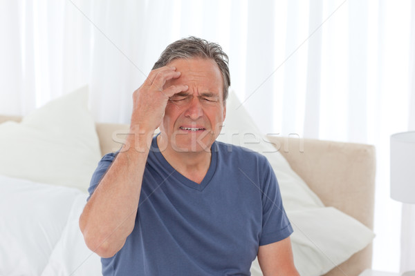 Man having a headache on his bed Stock photo © wavebreak_media