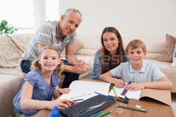 Happy parents helping her children to do their homework in their living room Stock photo © wavebreak_media